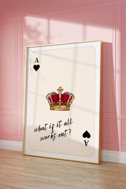 Framed playing card with a crown and text on a pink wall.