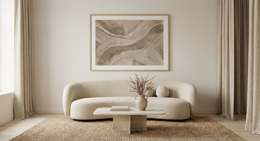 Minimalist beige living room with abstract wall art, curved sofa, and textured rug