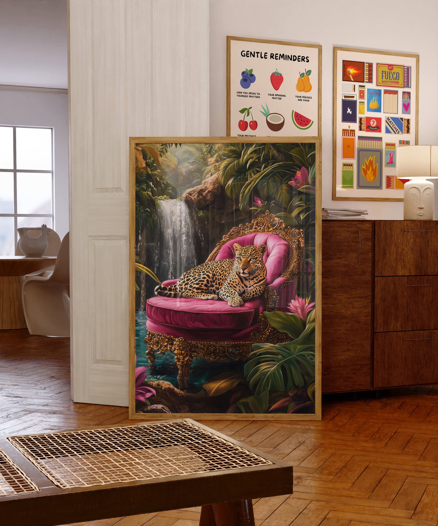 Framed artwork of a leopard on a pink chair in a room with other framed pictures.