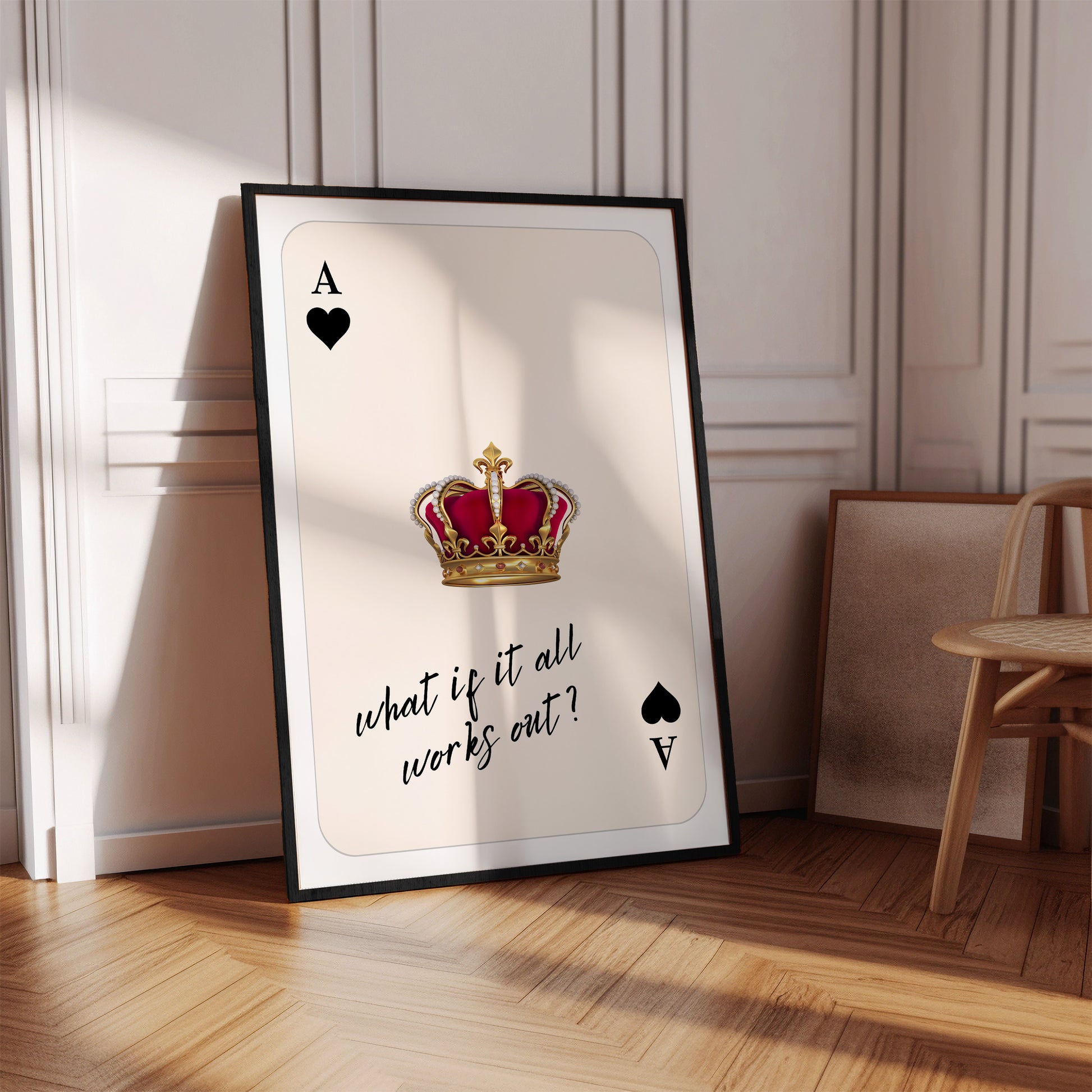 Framed poster with an ace of spades card design and a crown, placed on a wooden floor.