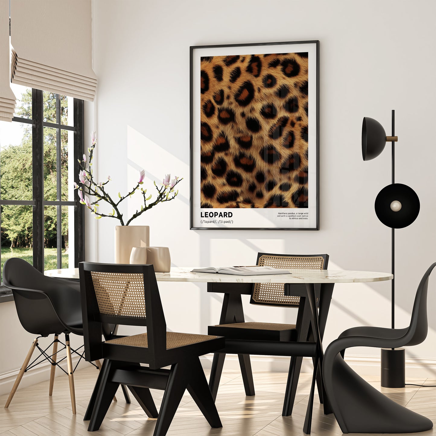 Dining room with a leopard print poster on the wall, black chairs, and a modern lamp.