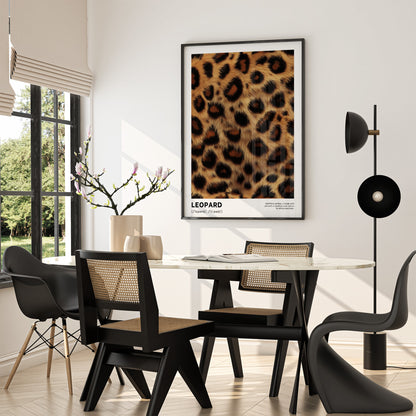 Dining room with a leopard print poster on the wall, black chairs, and a modern lamp.